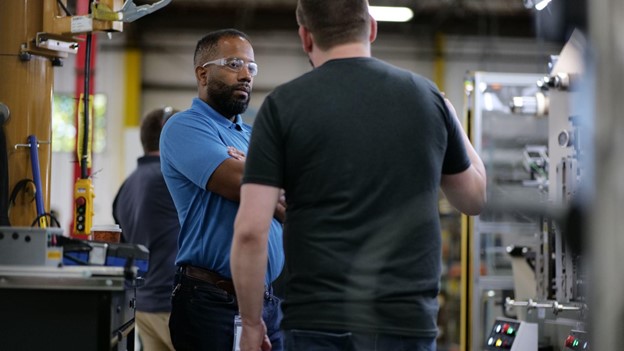 Men speaking to one another in a factory